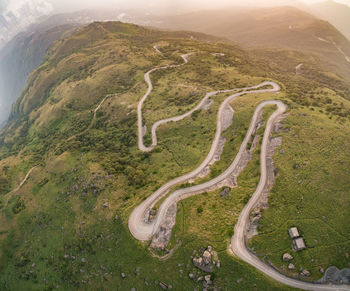 High angle view of winding road amidst green mountains