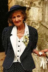 Portrait of smiling senior woman standing by wall