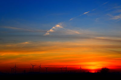 Silhouette of wind turbines at sunset