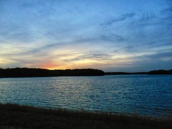 Scenic view of lake against sky at sunset