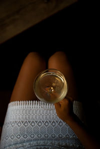 Close-up of hand holding drink on table