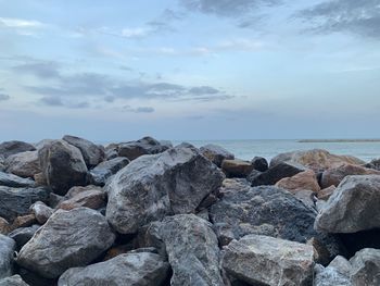 Rocks by sea against sky