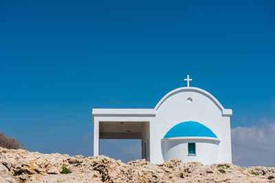 Traditional greek white chapel with a blue roof on the seaside. agioi anargyroi chapel, cyprus