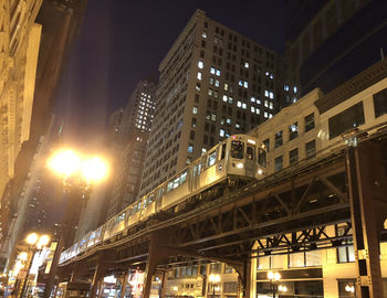 Low angle view of illuminated buildings against sky at night