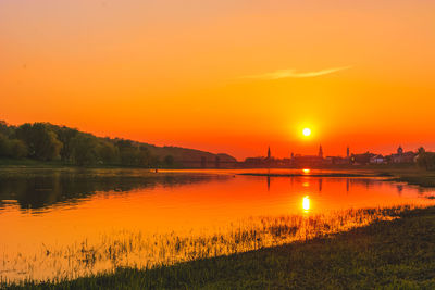 Scenic view of lake against romantic sky at sunset