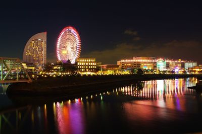 Illuminated ferris wheel in city at night