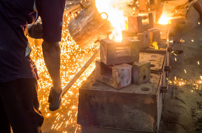 Man working with liquid metal at night