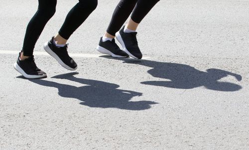 Low section of women standing on zebra crossing