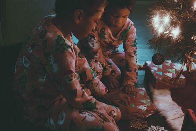 High angle view of girls opening gift while sitting at home