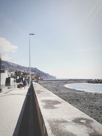 Surface level of road by sea against sky