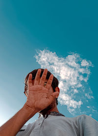 Low angle view of hand against sky