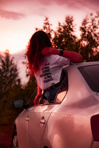 Rear view of woman against sky during sunset