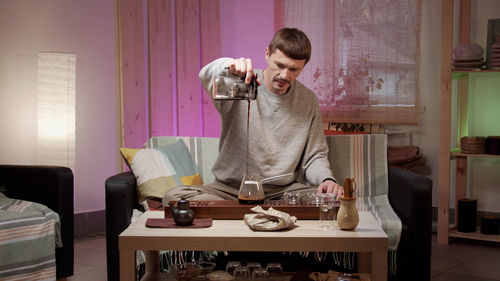 Man pouring coffee in cup at home