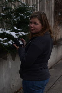 Smiling young woman standing outdoors