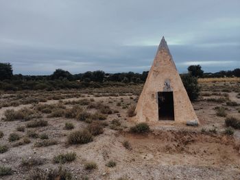 Built structure on countryside landscape against sky