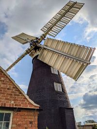 Low angle view of traditional windmill against sky