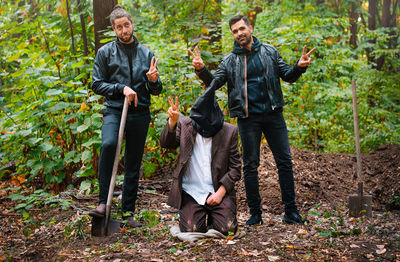 Full length of men standing in forest