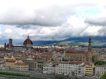 View of cityscape against cloudy sky