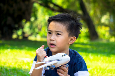 Close-up of boy with airplane toy in park