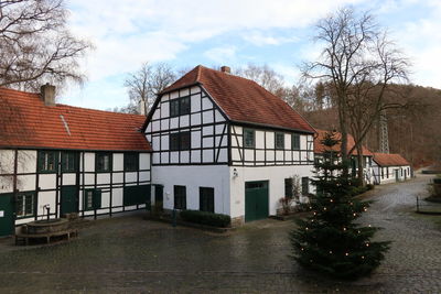 Houses by building against sky