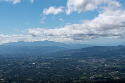 Aerial view of city against cloudy sky