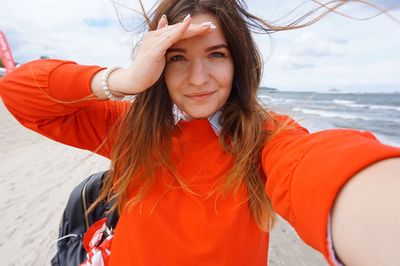 Portrait of young woman standing at beach