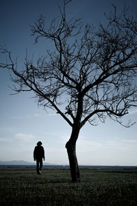 Rear view of silhouette man standing on field against sky