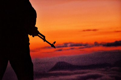 Silhouette man against orange sky during sunset