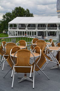 Empty chairs and tables at sidewalk cafe