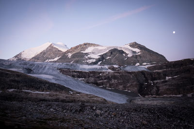 Scenic view of snowcapped mountains against sky at night