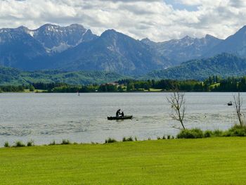 Scenic view of lake by mountains against sky