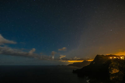 Scenic view of atlantic ocean against starry sky at night