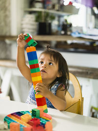 Girl stacking blocks at table