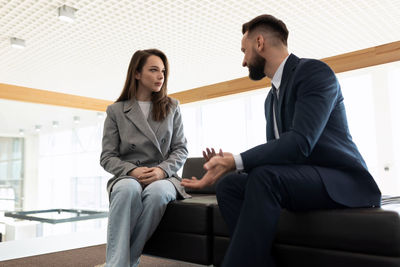 Business colleagues discussing sitting on couch