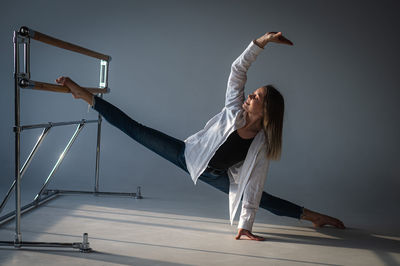 Full length of young woman jumping against sky