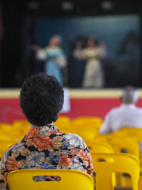 Rear view of woman sitting on chair