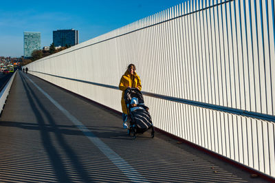 Rear view of man walking on bridge