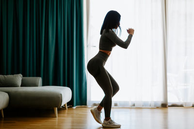 Side view of woman standing at home