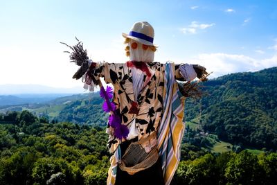 Scarecrow against landscape and sky