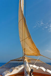 Sailboat sailing in sea against blue sky