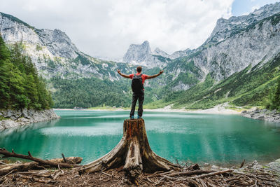 Full length of man standing by lake against mountains