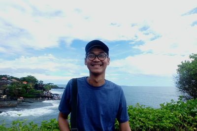Portrait of smiling mid adult man against lake