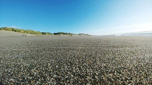 Scenic view of beach against clear blue sky