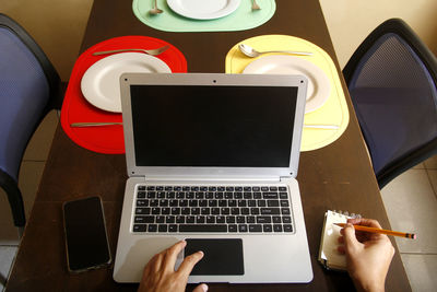 Low section of person using laptop on table