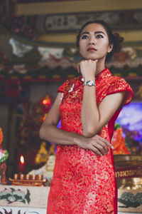 Young woman standing with hand on chin