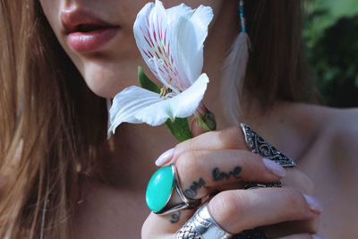 Midsection of woman holding white lily