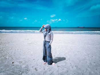 Full length of man standing on beach against sky