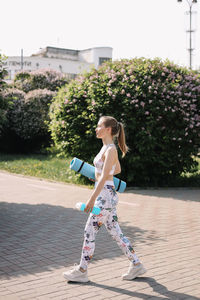 Happy fun healthy athletic girl in sportswear training and exercising in the park in nature outdoors