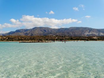 Scenic view of sea and mountains against sky