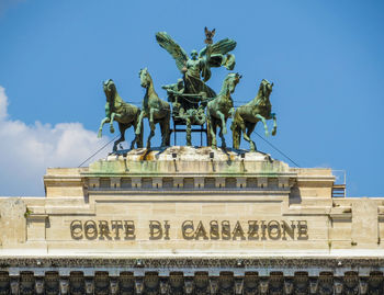 Low angle view of statue against blue sky